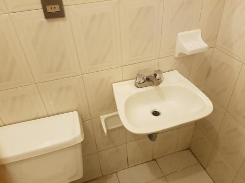een badkamer met een witte wastafel en een toilet bij Hotel maris in Ixtapan de la Sal