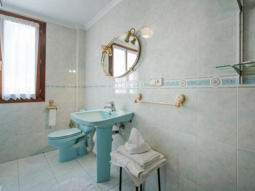 La salle de bains est pourvue d'un lavabo bleu et de toilettes. dans l'établissement Inviting mansion in Salinillas de Buradón with pool, à Salinillas de Buradón