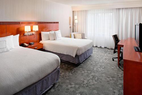 a hotel room with two beds and a desk at Courtyard Durham Near Duke University/Downtown in Durham