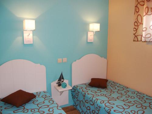 - une chambre avec 2 lits dans une chambre aux murs bleus dans l'établissement Apartment in Jardins de Neptune with Terrace, à Saint Cyprien Plage