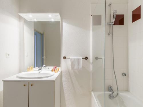 uma casa de banho branca com um lavatório e um chuveiro em Nice apartment with a dishwasher near a recreational lake em Aureilhan