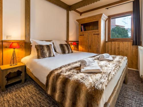 une chambre avec un grand lit avec des serviettes dessus dans l'établissement Chalet in Les Arcs with Heated Pool, à Arc 2000