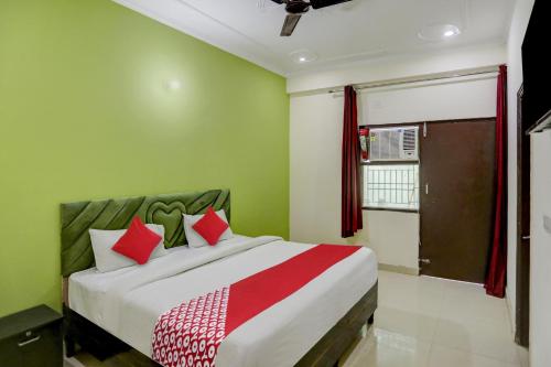 1 dormitorio con 1 cama grande con almohadas rojas en OYO Flagship 81023 Hotel The Orchid, en Noida