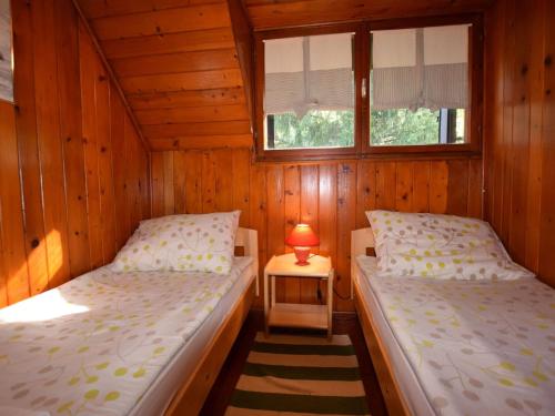 a bedroom with two beds and a lamp on a table at Restful Holiday Home in Vrbovsko with Garden and Barbecue in Vrbovsko