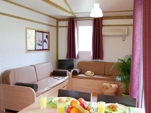 - un salon avec une table et des fruits dans l'établissement Chalet in France with Garden Terrace, à Castelmoron-sur-Lot