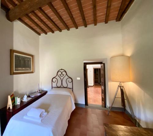 um quarto com uma grande cama branca e um candeeiro em Residenza Villa Degli Ochi em Sagginale
