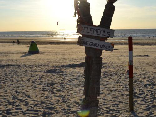 a pole on the beach with signs on it at Bungalow in 's-Gravenzande with Nautical Charm in 's-Gravenzande