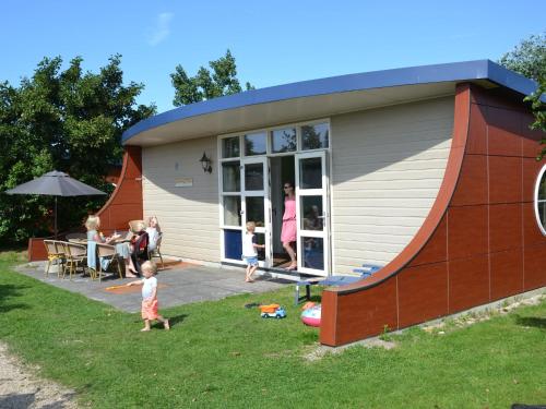 a family standing in front of a house at Bungalow in Netherlands with Ship-Like Design in 's-Gravenzande