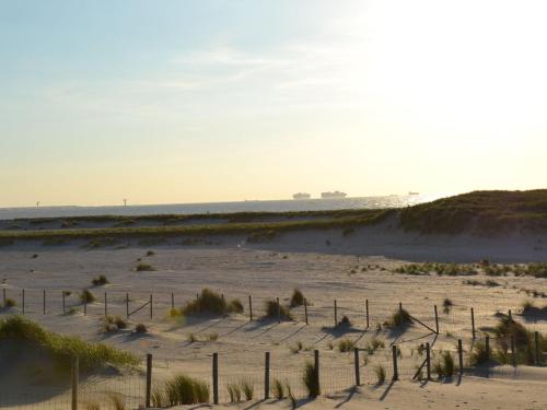 a beach with a fence in the sand at Bungalow in Netherlands with Ship-Like Design in 's-Gravenzande