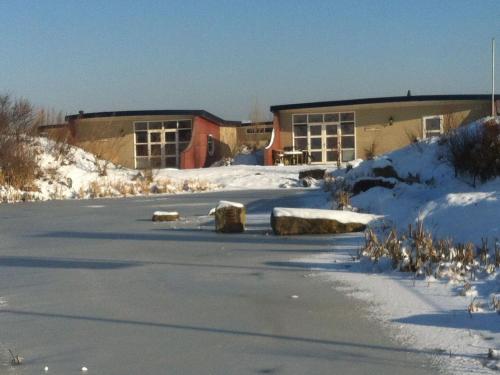 a building in the snow next to a parking lot at Bungalow in Netherlands with Ship-Like Design in 's-Gravenzande