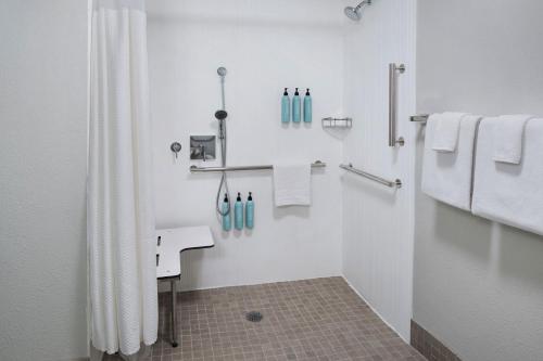 a bathroom with a shower and a sink and towels at Courtyard by Marriott New Haven Wallingford in Wallingford