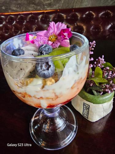 a glass vase filled with ice cream and flowers on a table at Central Guesthouse Chiang Rai - Bread & Breakfast in Chiang Rai