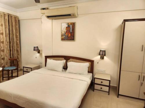 a bedroom with a large bed with white sheets at BeachWalk Tulip Apartments Vagator in Vagator