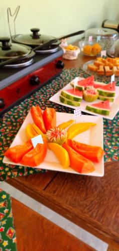 uma mesa coberta com pratos de frutas e produtos hortícolas em Arraia Suítes Pousada em Pipa