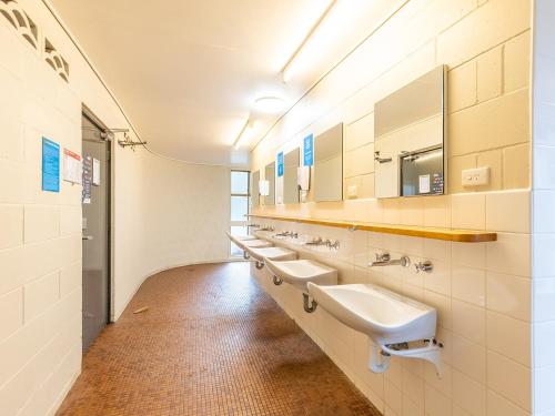 a bathroom with a row of sinks and mirrors at NRMA Bairnsdale Riverside Holiday Park in Bairnsdale