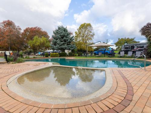a large swimming pool in a brick patio with at NRMA Bairnsdale Riverside Holiday Park in Bairnsdale