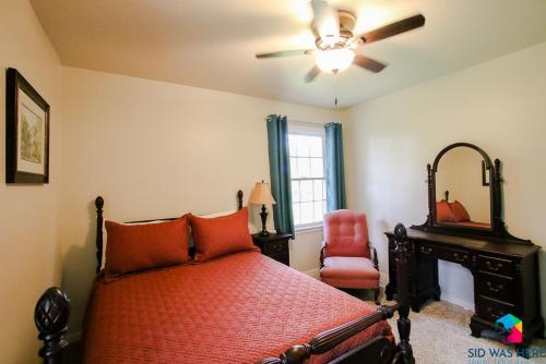 a bedroom with a bed and a fan and a chair at Savannah Home In Northwood in Savannah