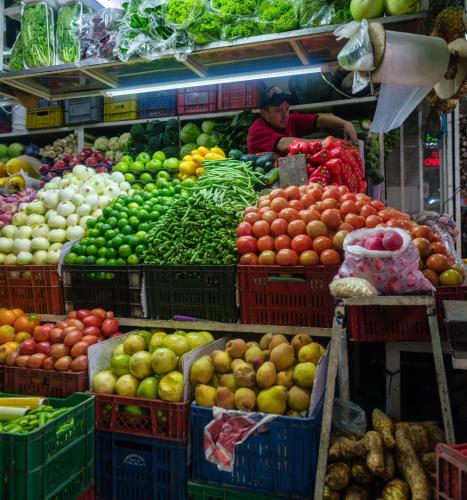 a market with many baskets of fruits and vegetables at Hotel Artistico in Bogotá