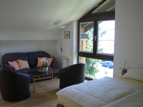 a bedroom with a bed and a couch and a table at Ferienwohnung Mautweg in Bad Reichenhall