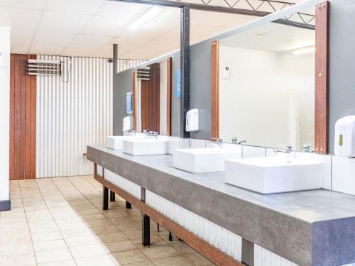 a bathroom with three sinks and two mirrors at NRMA Yarrawonga Mulwala Holiday Park in Mulwala