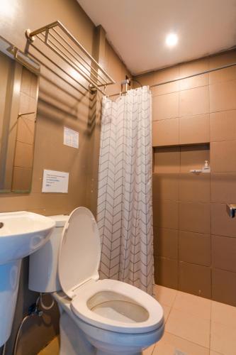 a bathroom with a toilet and a sink and a shower at The Ridge Coron in Coron