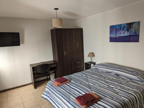Dormitorio con cama, escritorio y TV en Don Trujo en Mendoza