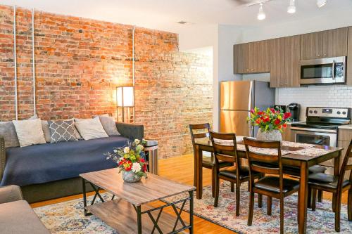 uma sala de estar e cozinha com uma parede de tijolos em Cityscape 2 -Sleep 7 em Chattanooga