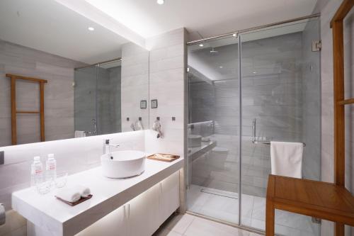 a bathroom with a sink and a shower at Jiushui Heyuan Art Design Hotel in Qingdao