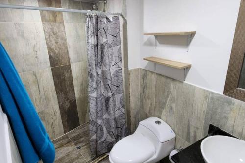 een badkamer met een toilet en een douche bij Terranova, apto en el Salvador in Medellín