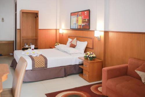una camera d'albergo con letto e sedia di WISMA KUSUMA HOTEL 