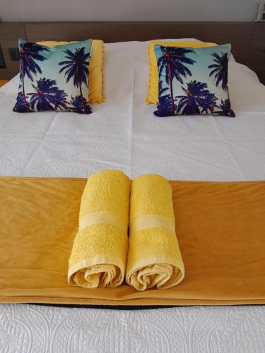 two towels on a wooden tray on a bed at Studio COEUR PASSION VUE MER charme et standing in Saint-François