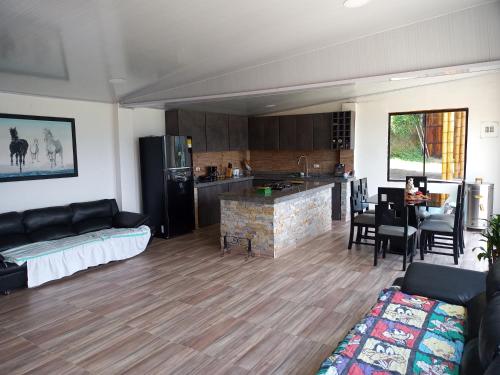 sala de estar con sofá y cocina en habitación en Villa Tina, en Santa Rosa de Cabal