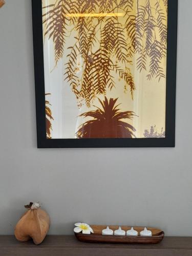 a picture hanging on a wall above a wooden table at Studio COEUR PASSION VUE MER charme et standing in Saint-François