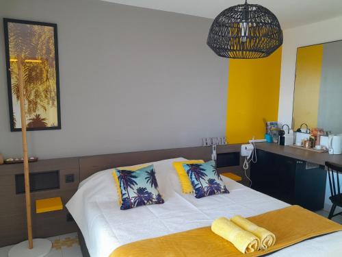a bedroom with a bed with a desk and a kitchen at Studio COEUR PASSION VUE MER charme et standing in Saint-François
