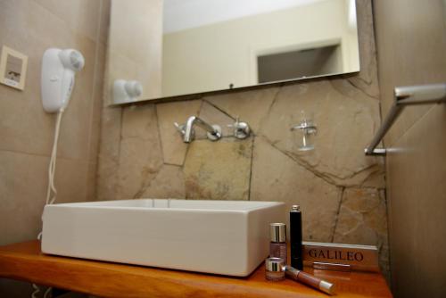 a bathroom with a white sink and a mirror at Galileo Boutique Hotel in San Carlos de Bariloche
