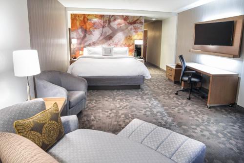 Habitación de hotel con cama grande y escritorio. en Courtyard by Marriott Lenox Berkshires, en Lenox