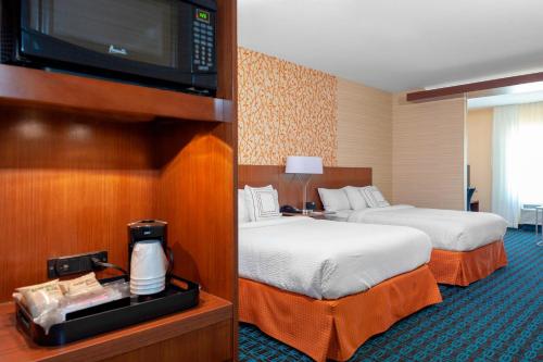 a hotel room with two beds and a flat screen tv at Fairfield Inn & Suites by Marriott Alamosa in Alamosa