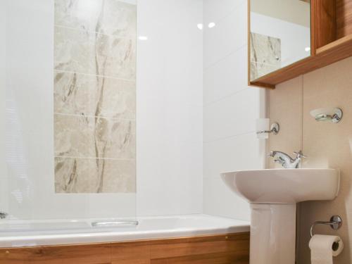 a bathroom with a sink and a toilet and a tub at Lodge 69 in Stonham Aspall