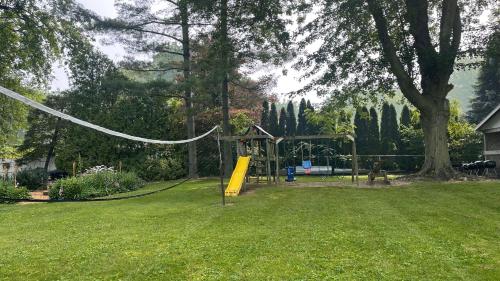 um parque infantil num quintal com uma árvore em Plantation Motel em Huron