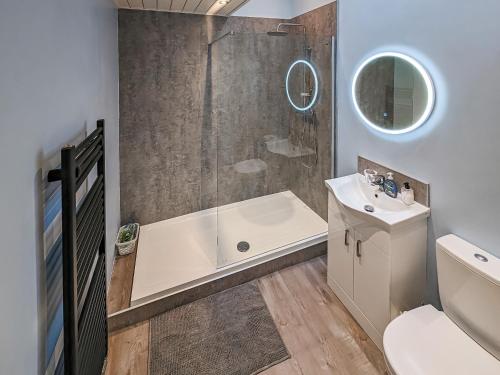 uma casa de banho com um chuveiro, uma banheira e um lavatório. em Delfryn em Pen-y-groes