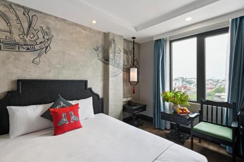 una camera da letto con un letto bianco con cuscini rossi di 22Land Residence Hotel & Spa 52 Ngo Huyen a Hanoi