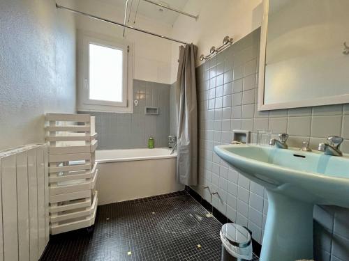 une salle de bain avec un lavabo et une baignoire et un lavabo dans l'établissement Appartement rénové 3 ch, parking, proche plage – Saint-Pierre-d’Oléron - FR-1-246A-269, à Saint-Pierre-dʼOléron