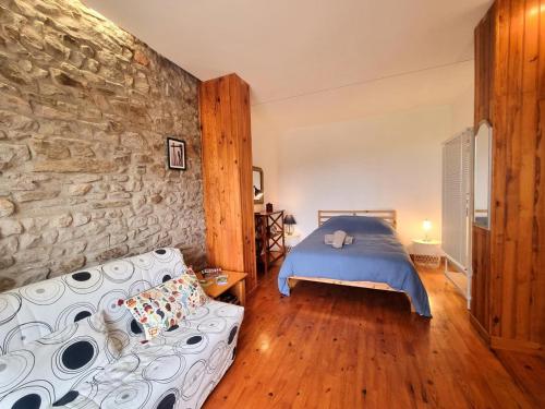 - une chambre avec un lit et un mur en pierre dans l'établissement Appartement Saint-Genest-Lerpt, 3 pièces, 4 personnes - FR-1-496-287, à Saint-Genest-Lerpt