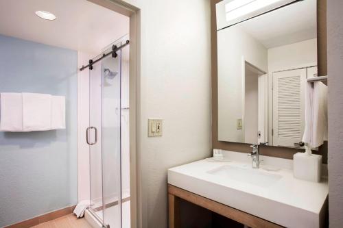 a bathroom with a sink and a mirror at Courtyard by Marriott Myrtle Beach Barefoot Landing in Myrtle Beach