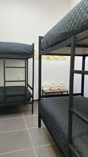 two bunk beds sitting next to each other in a room at CHECK INN HOSTAL AEROPUERTO GDL in Guadalajara