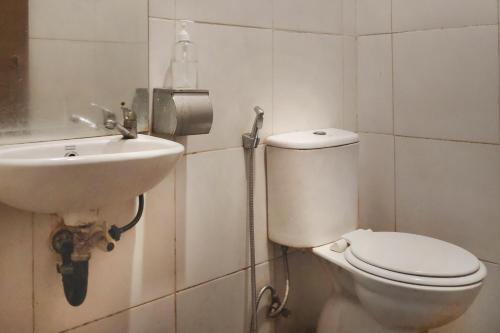 uma casa de banho com um WC e um lavatório em Urbanview Os Residence Medan by RedDoorz em Medan
