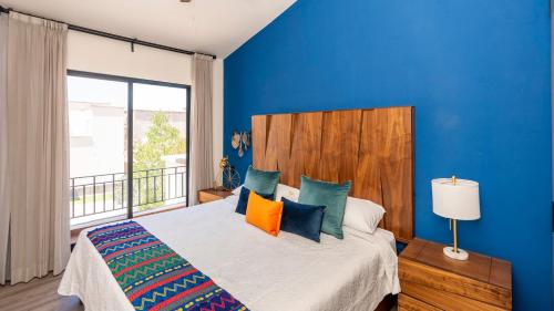 um quarto azul com uma cama e uma grande janela em Private Sanctuary 4BR Home with Pools and Gym em San Miguel de Allende