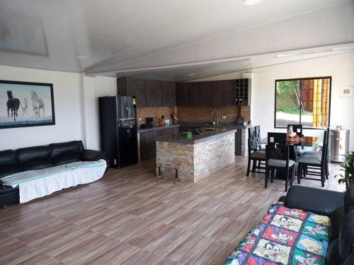 uma sala de estar com um sofá e uma cozinha em Hermosa casa campestre em Santa Rosa de Cabal