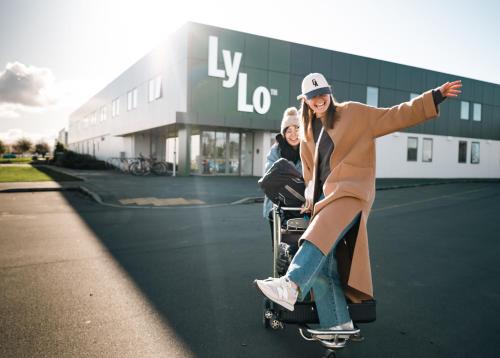 a woman riding a skateboard in front of a building at LyLo Christchurch in Christchurch