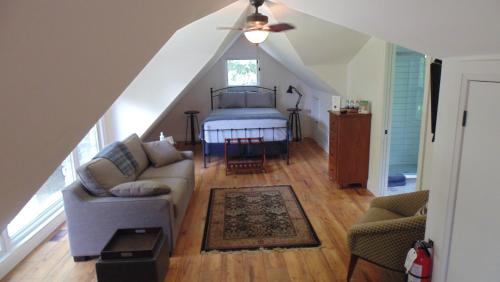 a living room with a bed and a couch at Carriage House On Kent in Niagara on the Lake